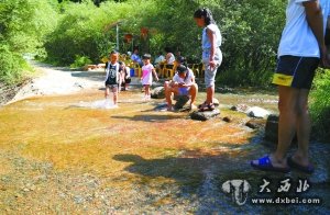 游客在兴隆山景区河道内戏水