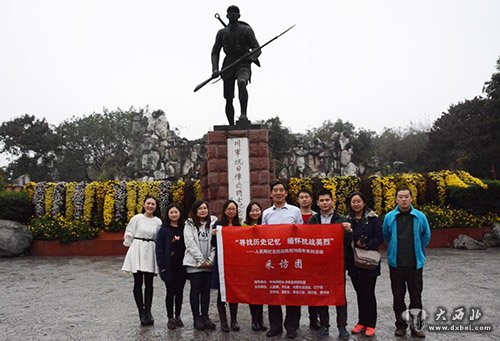 人民网前方报道团在位于成都市人民公园门前屹立的川军抗日阵亡将士纪念碑前合影留念